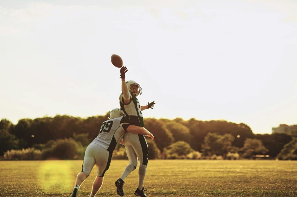 Football player getting tackled during a pass reception