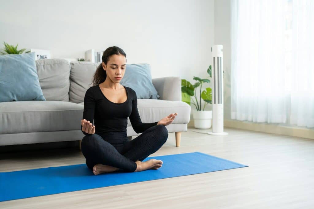 Latino young beautiful active woman doing Yoga Pilates workout at home.