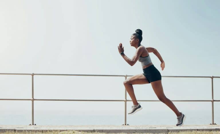 Sports, running and speed with black woman training in beach park for workout, wellness and health.