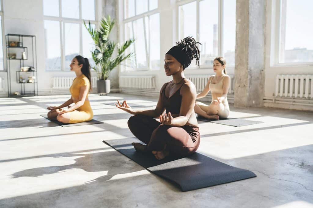 Women practicing yoga together in gym